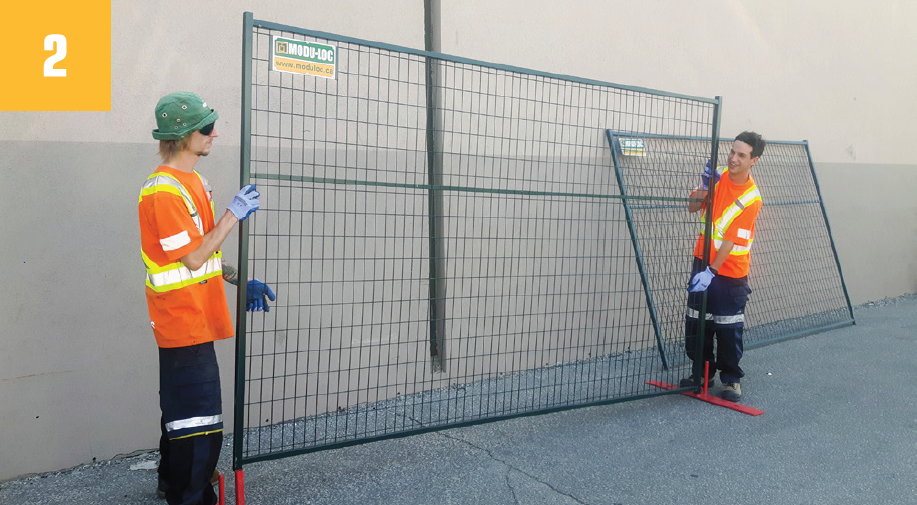 Two Fence Guys installing a Modu-Loc fence panel onto bases