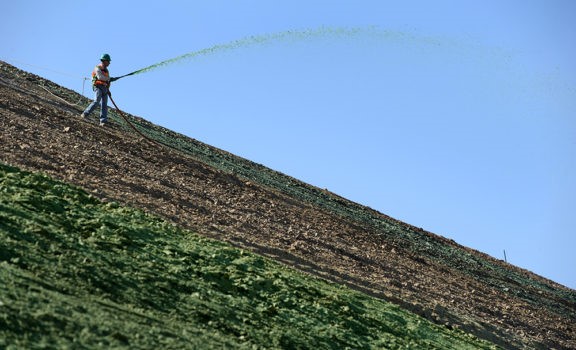 A worker spraying hydro-mulch