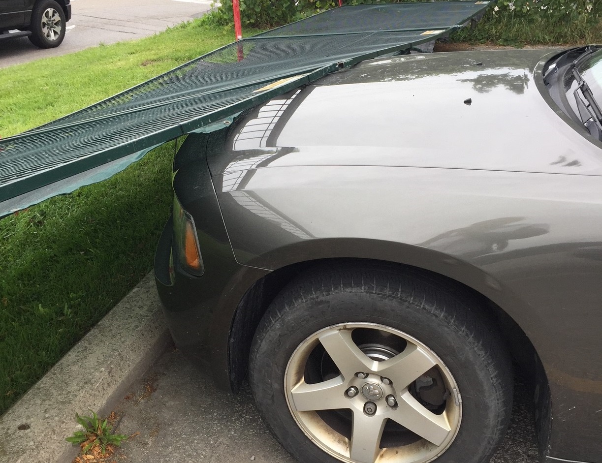 Temporary fence fallen on car