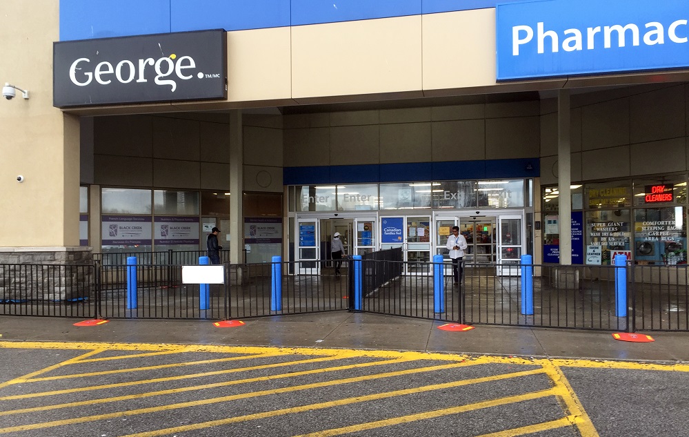 A photo of a large retail store with temporary fence being used to designate the entrance and exit